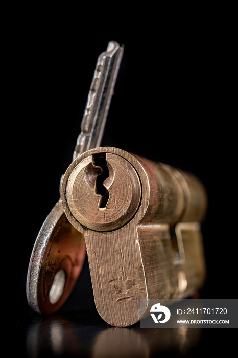 A old door lock on a dark background. A patent and keys to secure the front door.