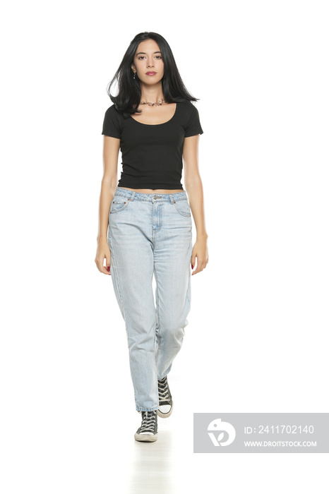 Young beautiful woman in loose jeans posing on white background