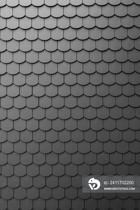 Fragment of a black roof of a private house made of shingles