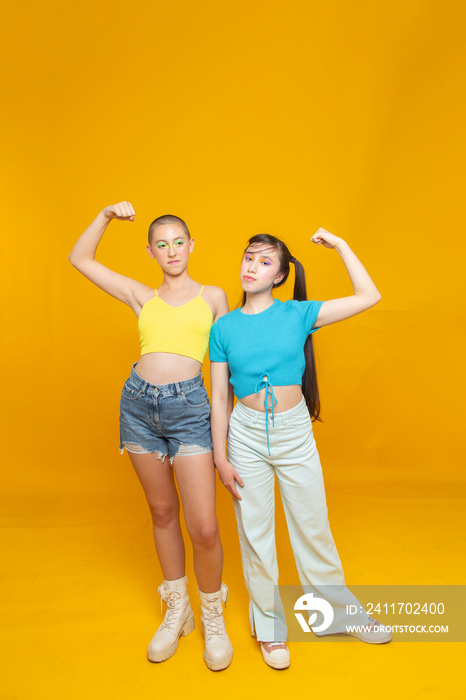 Studio portrait of stylish friends flexing muscles