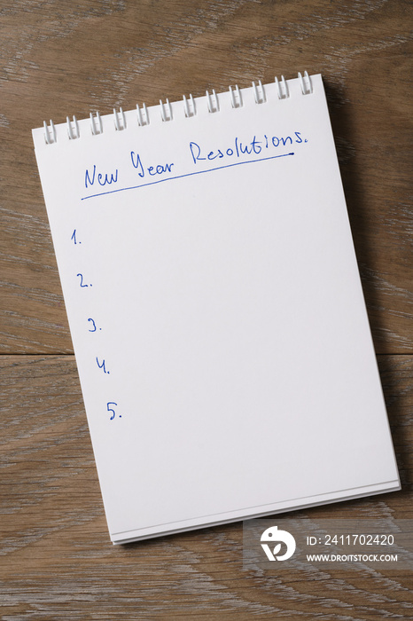 new year resolutions tempate with notepad on wood table