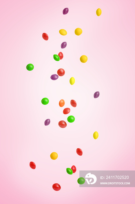 Falling colored candy, sweets. On a pink background