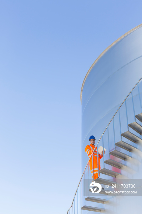 Portrait male worker on storage tank stairs