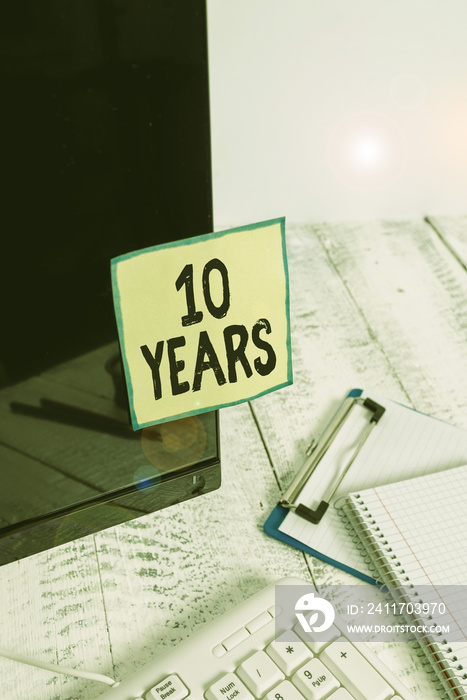 Text sign showing 10 Years. Business photo showcasing Remembering or honoring special day for being 10 years in existence Note paper taped to black computer screen near keyboard and stationary