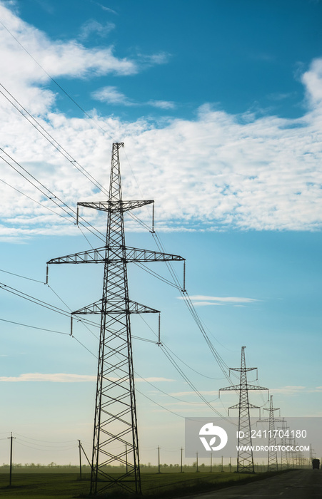 power lines along a highway at daytime with a cloudy deep blue sky