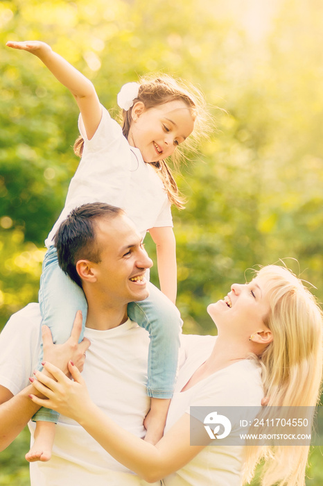 Happy family: mother father and child daughter on nature on sunset