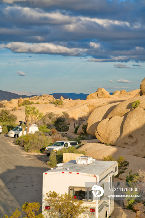 RVs parked amidst huge rocks at Joshua Tree National Park on a sunny day