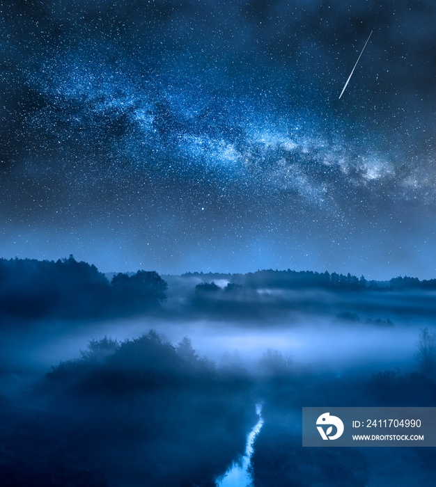 Milky way over foggy valley at night