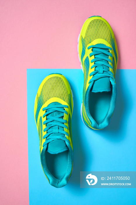 Pair of sport shoes on colorful background. New sneakers on pink and blue pastel background, copy space. Overhead shot of running shoes. Top view, flat lay