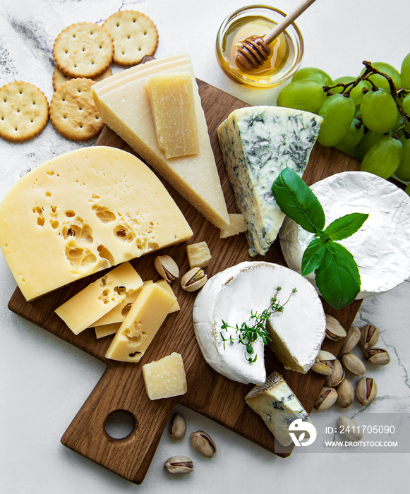 Various types of cheese, grapes and honey