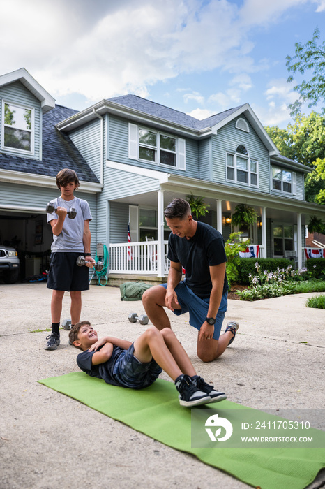 Air Force service member trains with his sons in a morning workout in preperation for a PT fitness test.