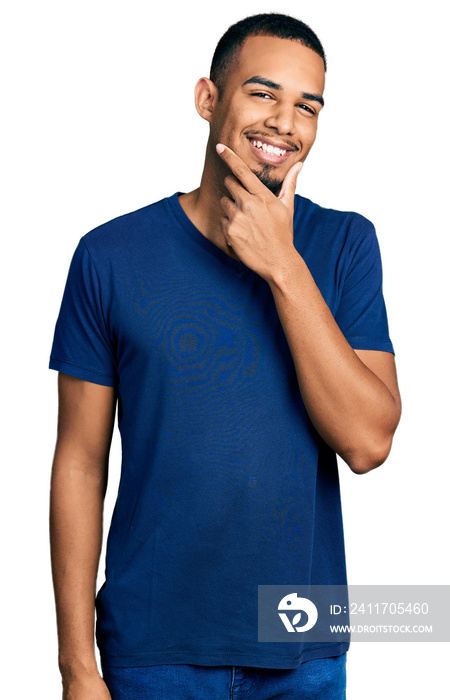 Young african american man wearing casual t shirt looking confident at the camera smiling with crossed arms and hand raised on chin. thinking positive.