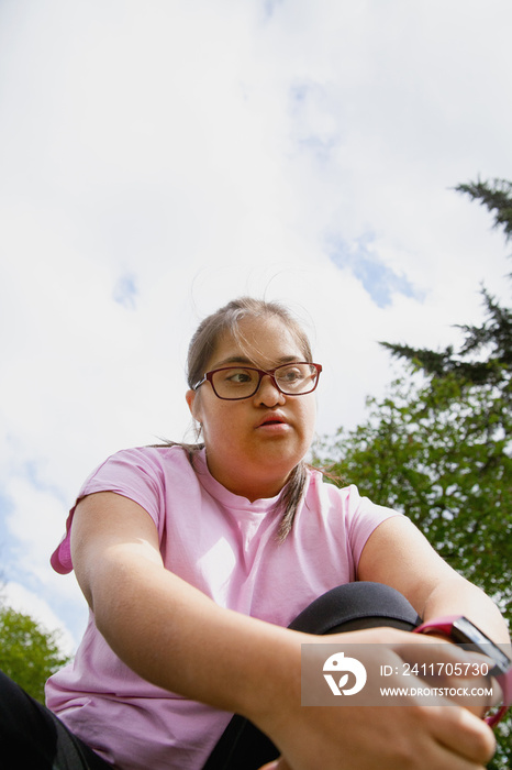 Young curvy girl with Down Syndrome relaxing after workout