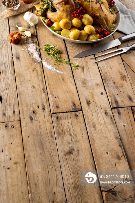 Overhead view of thanksgiving table roast turkey, potatoes, autumn decoration and copy space on wood