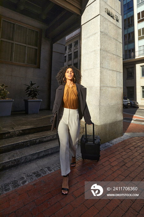 Business traveller arriving in the city with luggage in tow