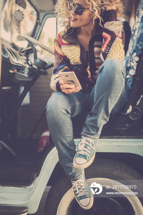 Smiling woman enjoying her road trip. Beautiful female wearing warm clothing and driving a van.  Independent adult female enjoy travel alone with minivan retro style