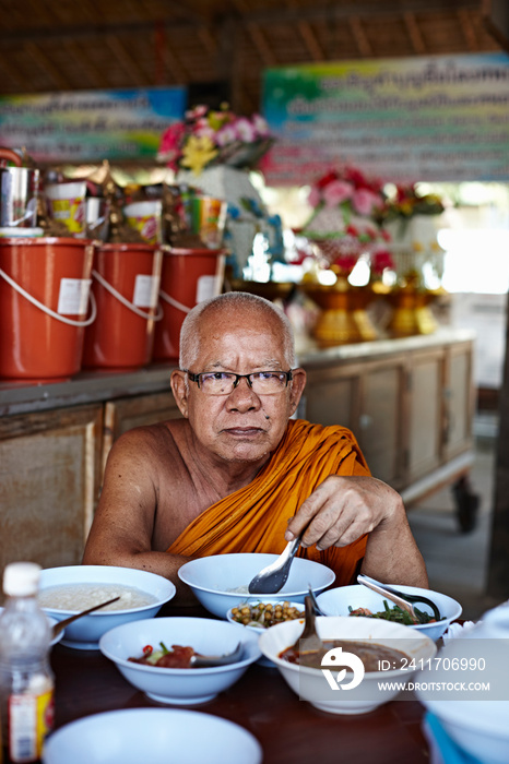 Buddhist monk eating, Damnoen Saduak Market, Thailand