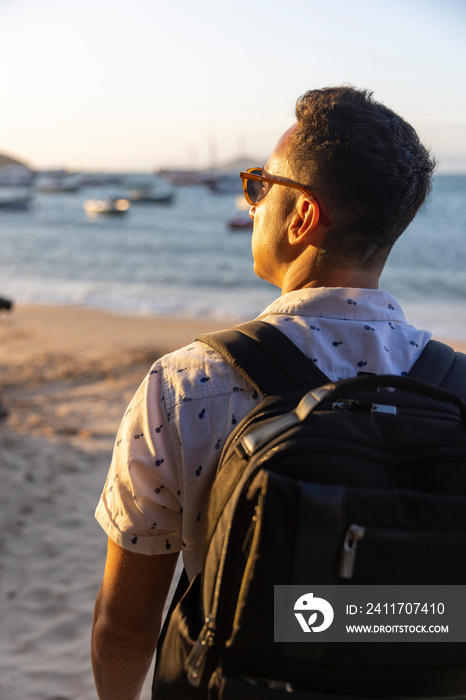 Rear view of man with backpack on beach