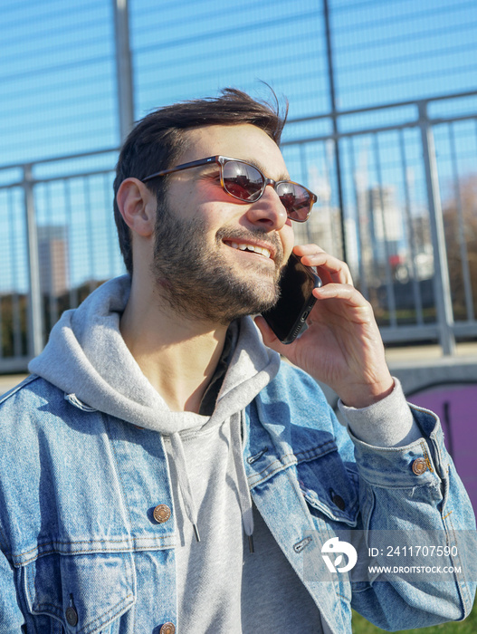 Smiling man talking on smart phone outdoors