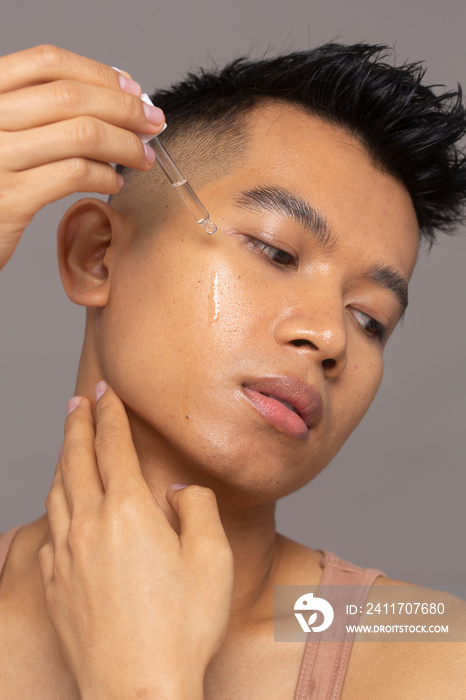 Close-up of person applying serum on face