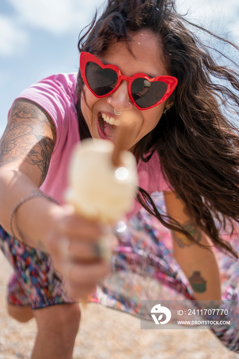 Smiling woman eating ice cream on beach