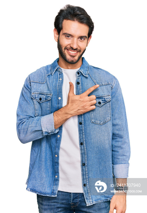 Young hispanic man wearing casual clothes cheerful with a smile on face pointing with hand and finger up to the side with happy and natural expression