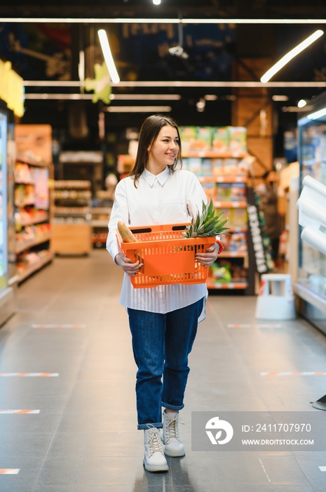 Woman grocery shopping and looking very happy