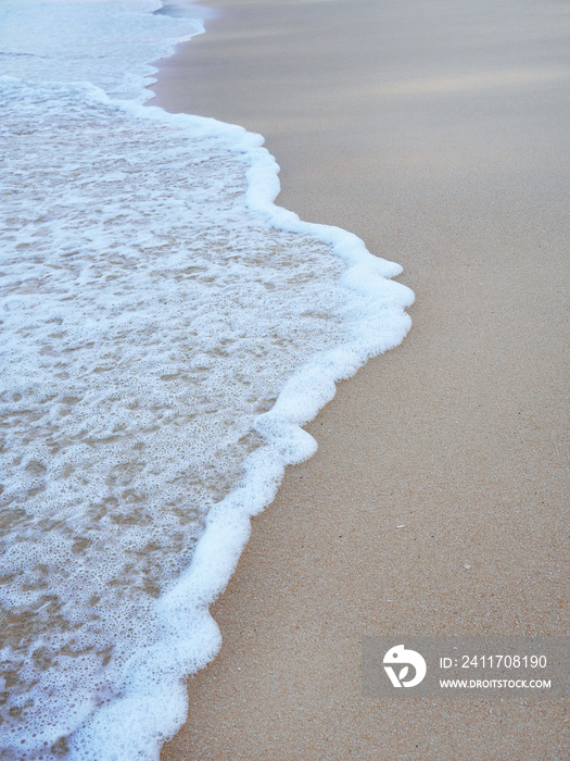 White wave splash on the sand beach for background wallpaper
