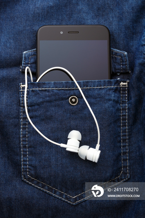 smartphone mobile in Blue jeans shirt pocket with black screen and white earphones