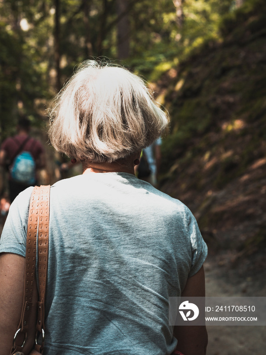 older woman with white hairs, view from behind,