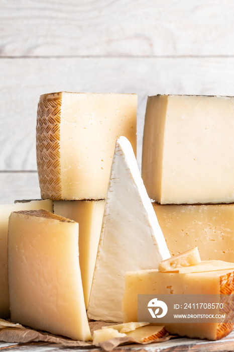 assorted manchego cheese on aged table, Various types of cheese composition on a light background, vertical image, place for text