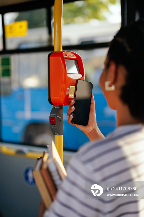 Woman paying bus fare with mobile app