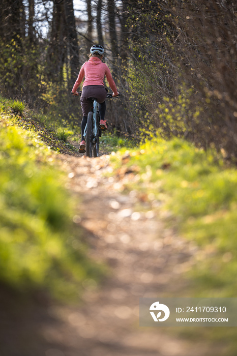 Pretty, young woman with her mountain bike going for a ride past the city limits, getting the daily dose of cardio