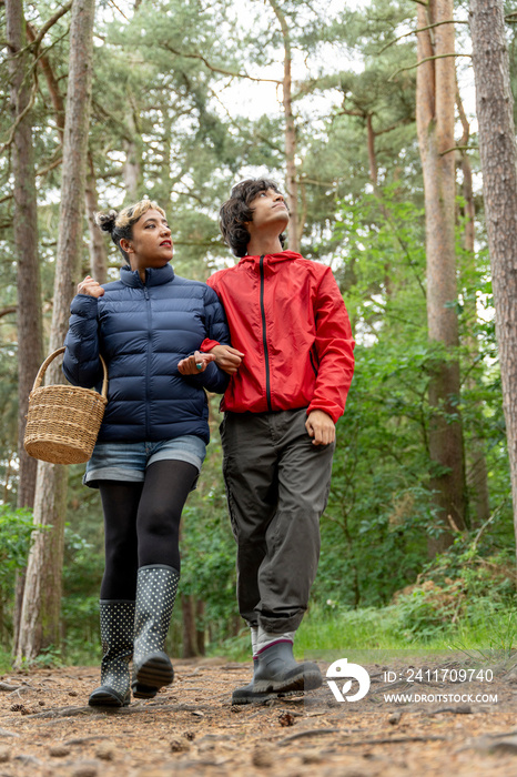 Mother and son walking in forest with basket