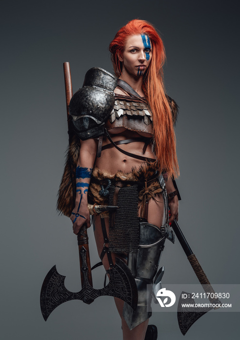 Beautiful woman in ancient scandinavian costume with axes