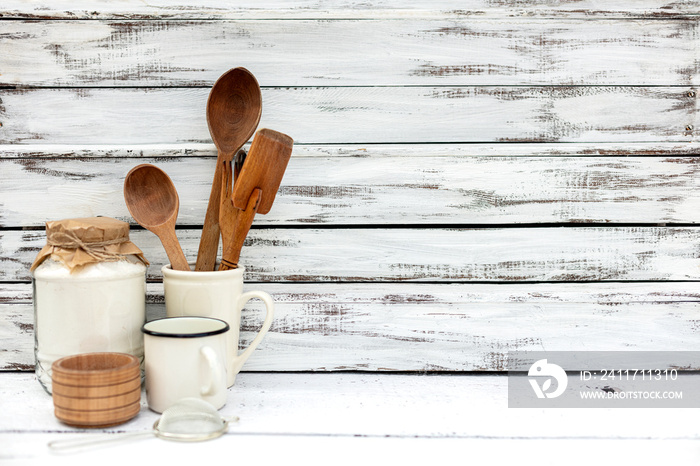 Vintage old baking utensils on a white wooden background.