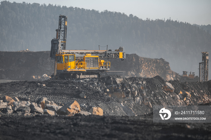 Drilling rigs borer drill wells for installing cast explosives blasting. Open mine coal and minerals from bowels soil explosion