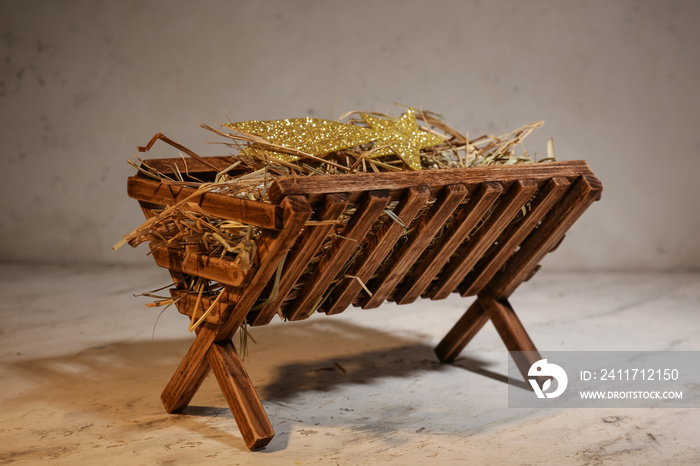 Manger with hay on light background