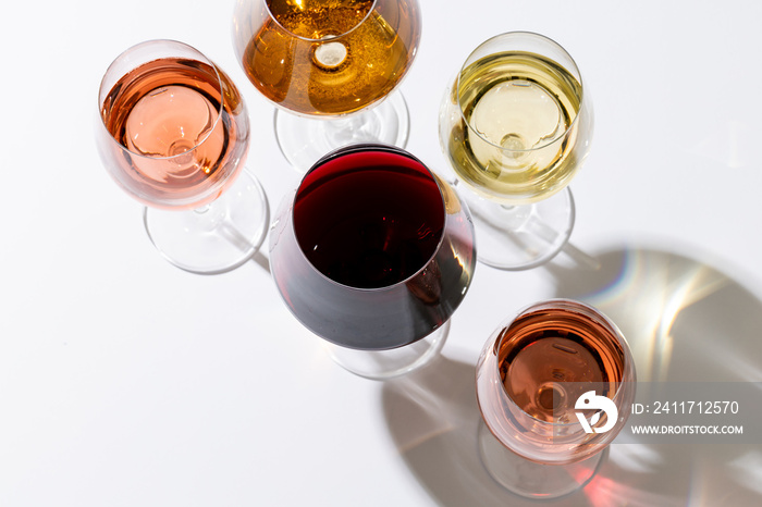 Glasses with red, rose and white wine on white background, with copy space