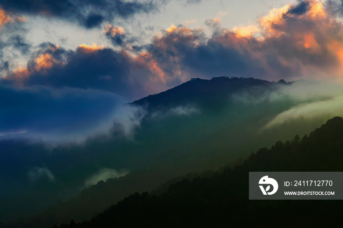 Colourful clouds above Himalayan mountain range after sun has set beyond the mountain peaks. After sun set nature stock image , shot at Okhrey, Sikkim, India.