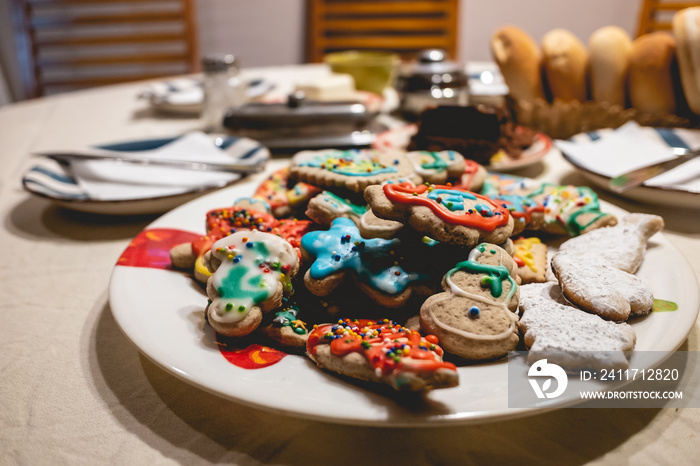 Delicious and colorful handmade holiday cookies on a plate on a tea time table