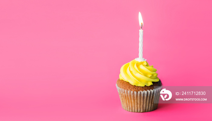 holiday, celebration, greeting and party concept - birthday cupcake with one burning candle over pink background