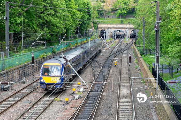 Train approaching Waverley station through Princes Street Gardens in Edinburgh, Scotland