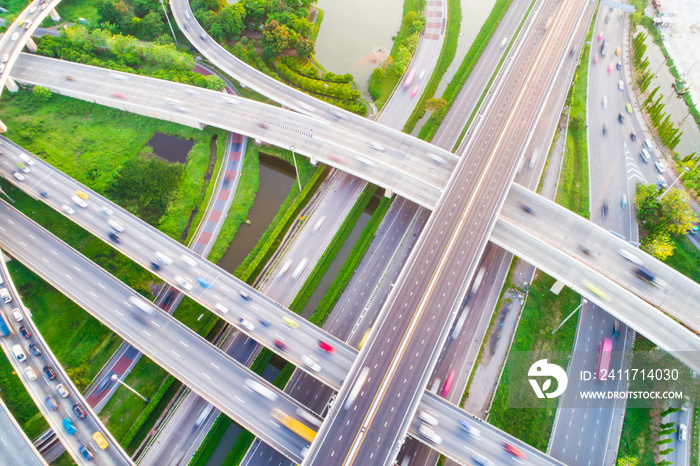 Aerial view car movement on traffic junction road with green tree park