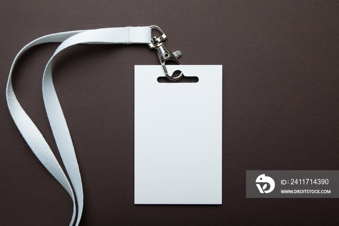 Empty blank badge identification card with white neckband isolated on brown background, space for text.