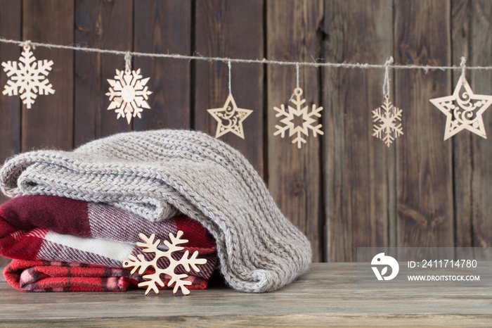 stack of plaids and Christmas decorations on wooden background