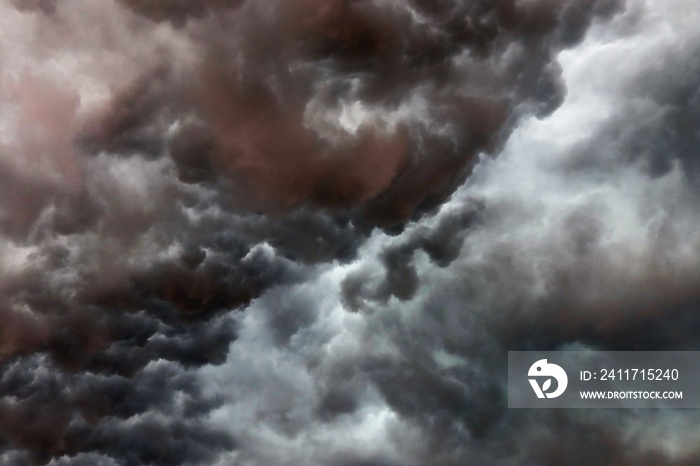 Very dark cloud formations of a heavy thunderstorm during sunset