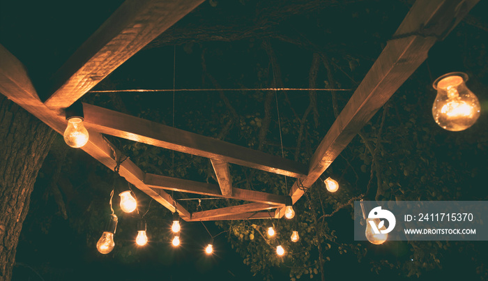 The garland from the retro bulbs hanging on the wooden planks