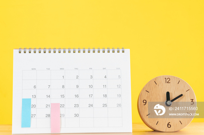 close up of calendar and clock on the table with yellow background, planning for business meeting or travel planning concept