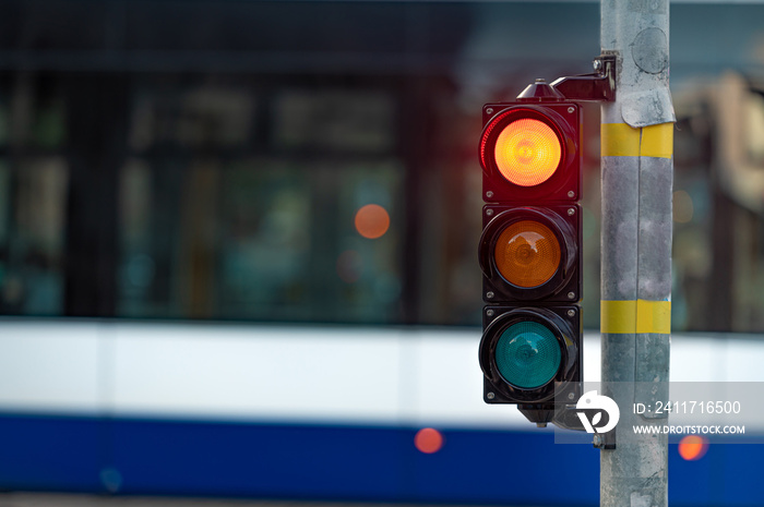 view of city traffic with traffic lights, in the foreground a traffic light with a red light